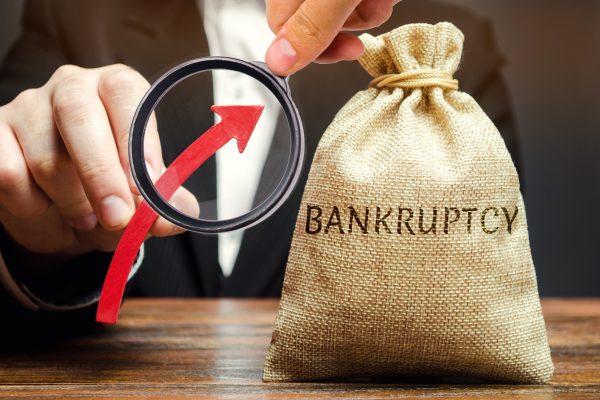 A bag with the word Bankruptcy and an up arrow in the hands of a businessman